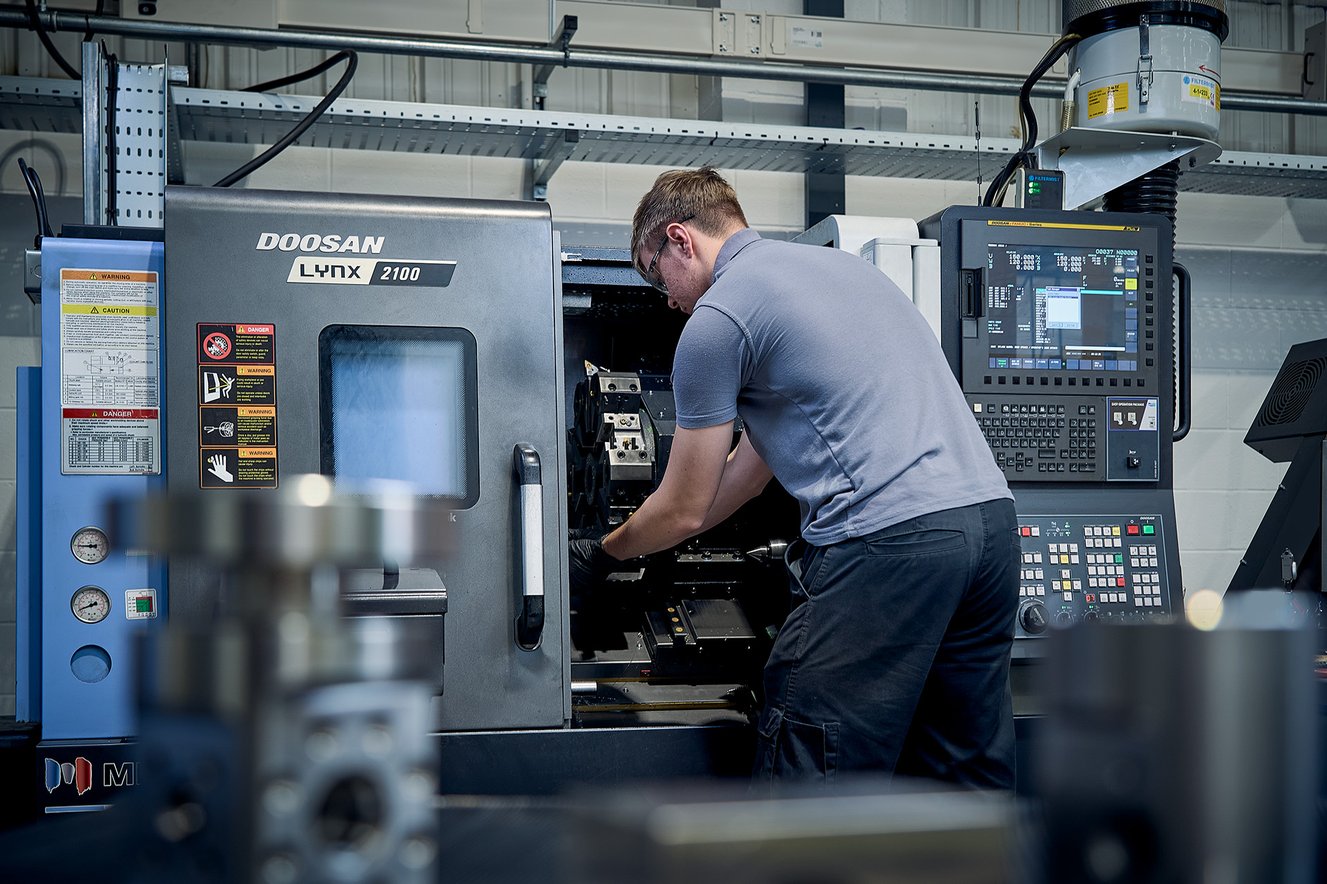 Colson Valves engineer operating Doosan Lynx 2100 CNC lathe during precision valve component production